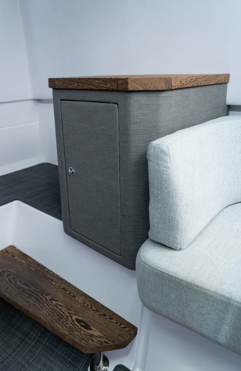 Slide: The Image of 2022 Axopar XC Aft Cabin interior with wooden accents and cushioned seating. - 25