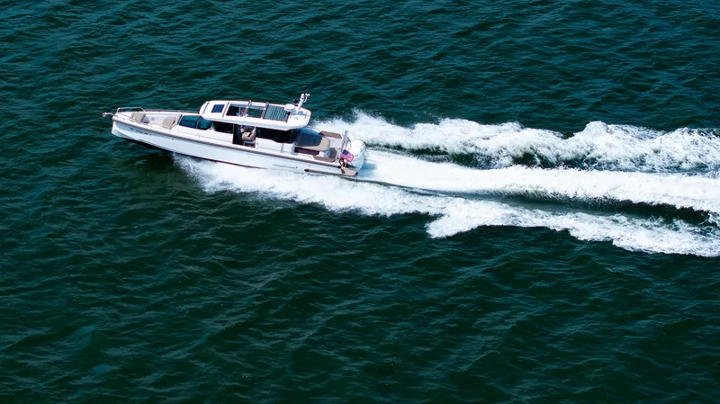 Slide: The Image of 2022 Axopar XC Aft Cabin boat cruising on open water, creating a wake. - 33