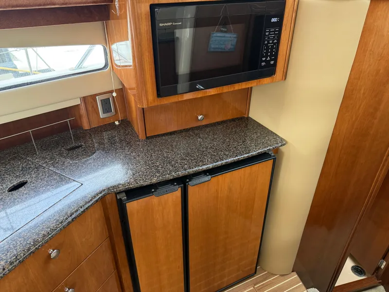 Slide: The Image of 2006 Meridian 391 Sedan kitchen with granite countertop, microwave, and dual mini-fridge. - 17