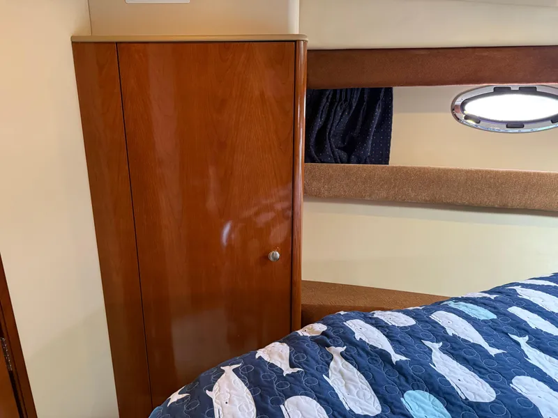Slide: The Image of 2006 Meridian 391 Sedan interior with wooden cabinet and nautical-themed bedding. - 20