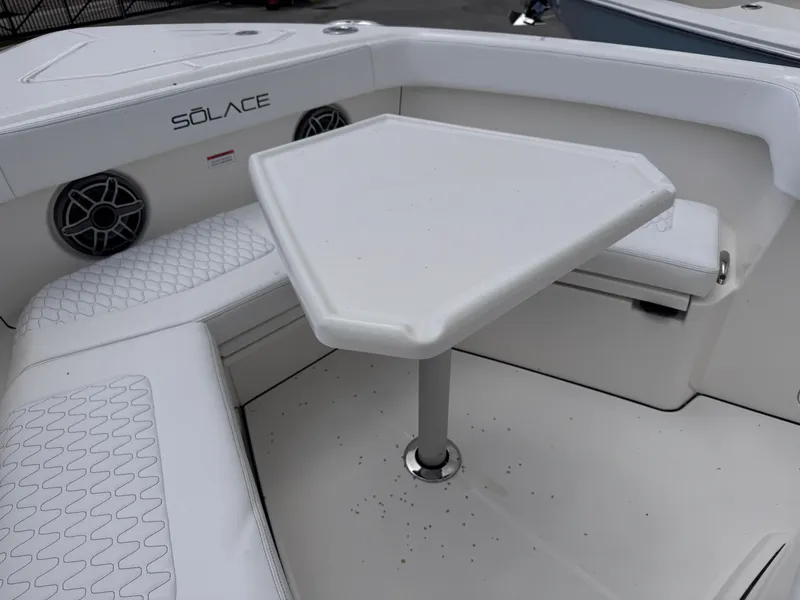 Slide: The Image of 2025 Solace 32 CS boat interior with white seating and triangular table. - 13