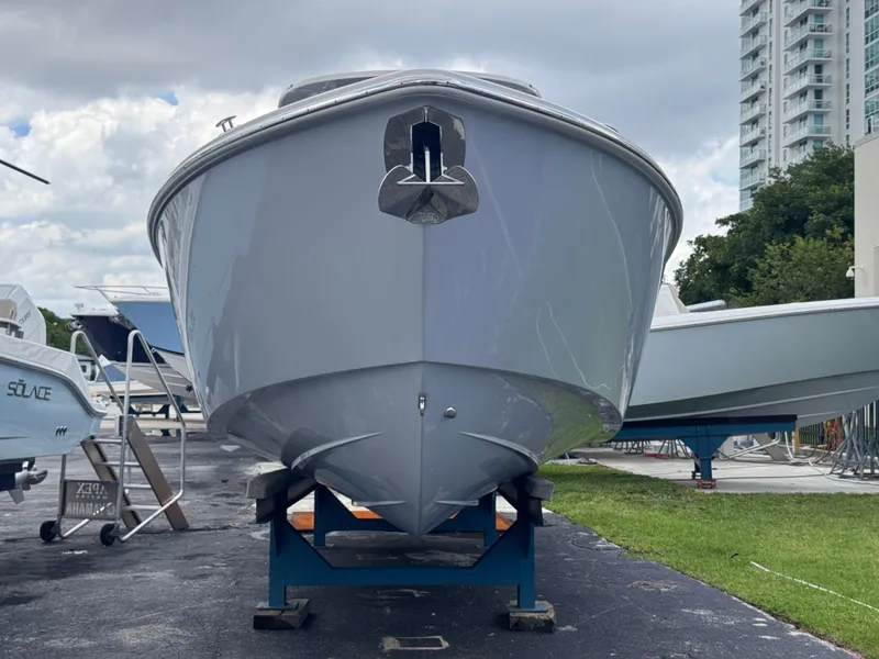 Slide: The Image of 2025 Solace 32 CS boat on display, front view, with urban background. - 2