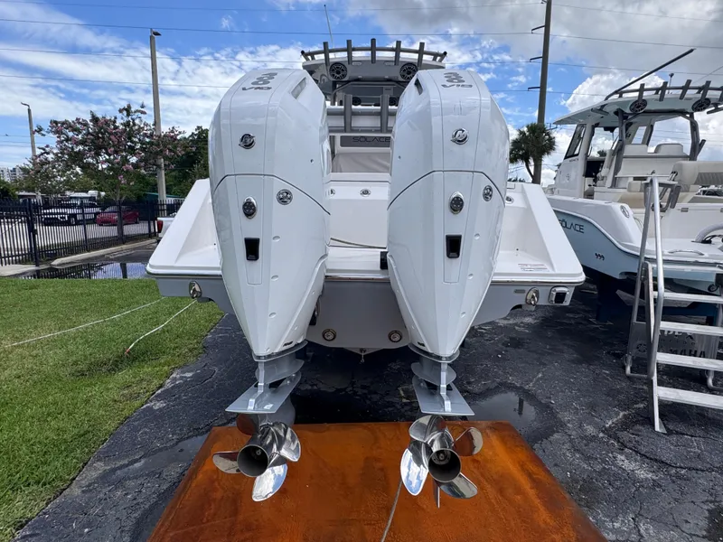 Slide: The Image of 2025 Solace 32 CS boat with dual outboard engines, displayed outdoors on a sunny day. - 3