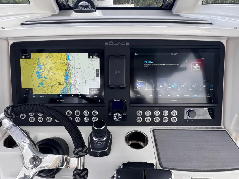 Slide: The Image of Dashboard of 2025 Solace 32 CS boat with dual navigation screens and controls. - 32