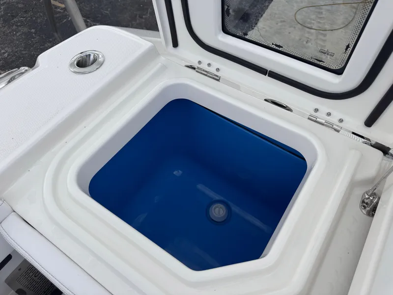 Slide: The Image of Livewell compartment on a 2025 Solace 32 CS boat, featuring a blue interior. - 42