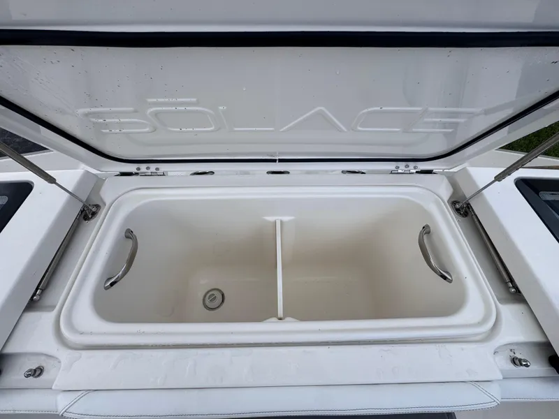 Slide: The Image of Open storage compartment of 2025 Solace 32 CS boat, featuring sleek design and sturdy handles. - 46