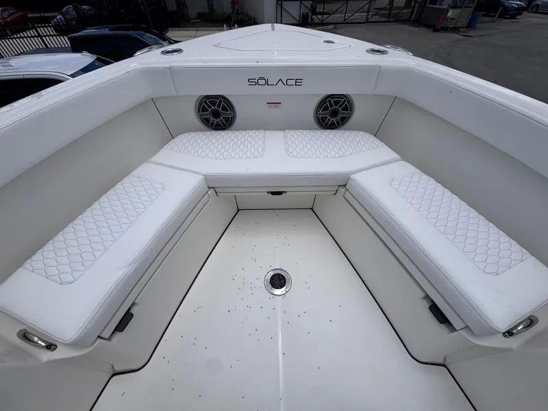 Slide: The Image of Bow seating area of 2025 Solace 32 CS boat with white cushions and speakers. - 9