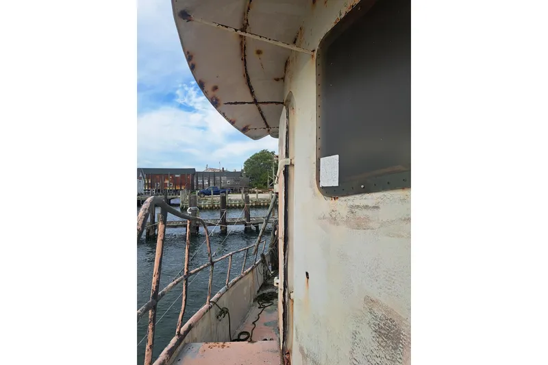 Slide: The Image of Rustic 1979 Custom Steel Trawler Dragger docked by the waterfront. - 10