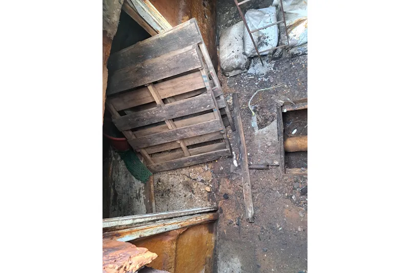 Slide: The Image of Interior of a 1979 Custom Steel Trawler Dragger with wooden pallets and debris. - 14