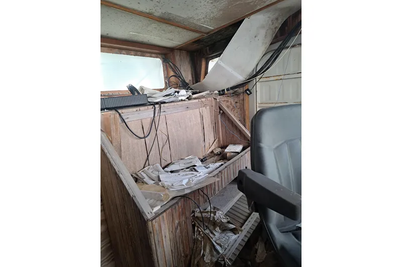 Slide: The Image of Interior of a 1979 Custom Steel Trawler Dragger, showing cluttered control area. - 20