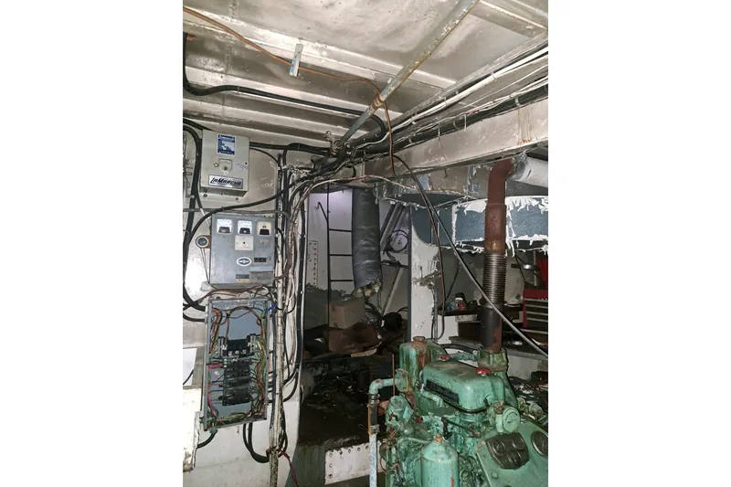 Slide: The Image of Engine room of a 1979 Custom Steel Trawler Dragger with visible wiring and machinery. - 23