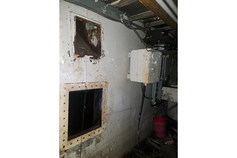 Slide: The Image of Interior of a 1979 Custom Steel Trawler Dragger, showing machinery and rusted components. - 26