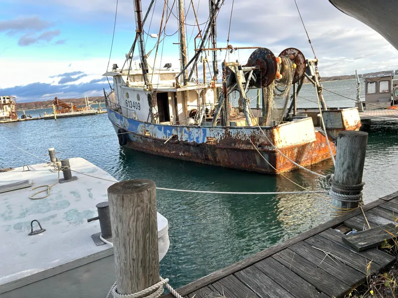 Slide: The Image of Old 1979 Custom Steel Trawler Dragger docked at a marina, showing signs of rust. - 6