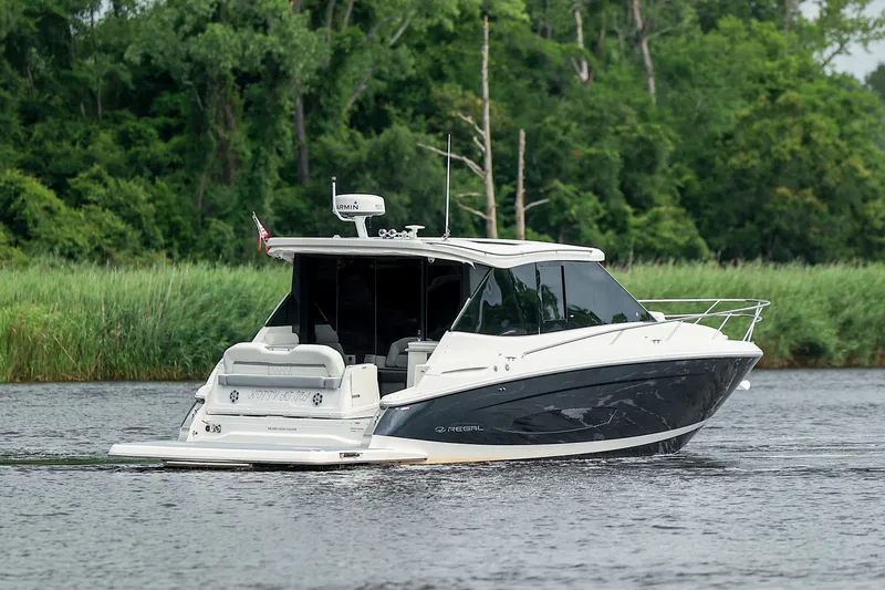 Slide: The Image of 2022 Regal 36 Grande Coupe cruising on a serene river with lush greenery. - 28