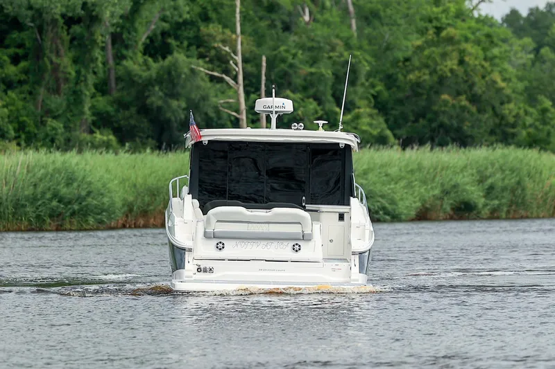 Slide: The Image of 2022 Regal 36 Grande Coupe cruising on a river with lush green surroundings. - 30