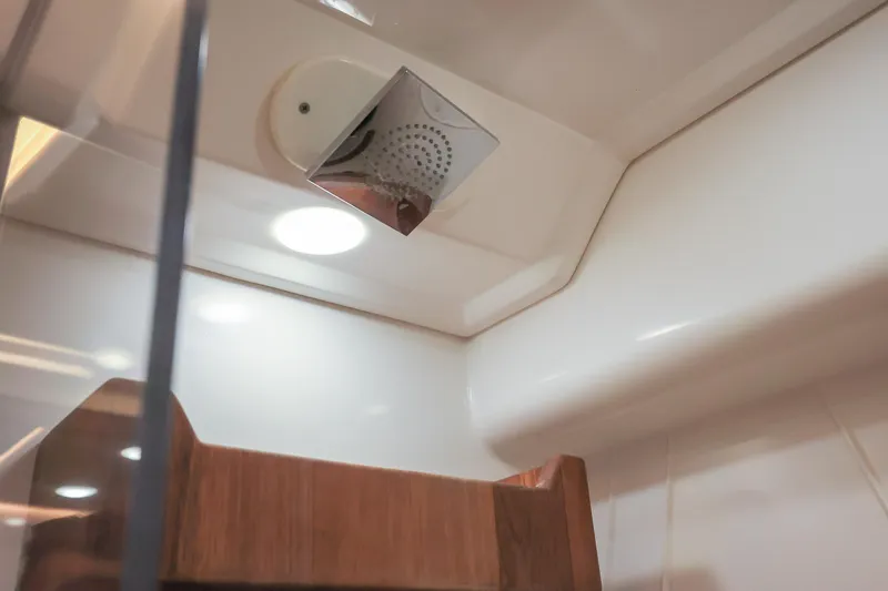 Slide: The Image of Interior of 2022 Regal 36 Grande Coupe, featuring modern showerhead and wooden accents. - 39