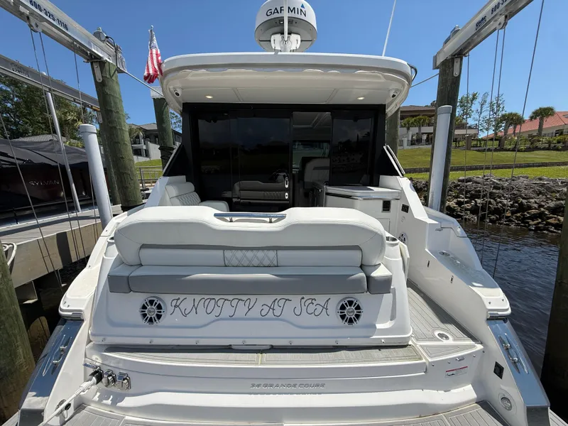 Slide: The Image of 2022 Regal 36 Grande Coupe yacht docked, rear view with "Knotty at Sea" text. - 4