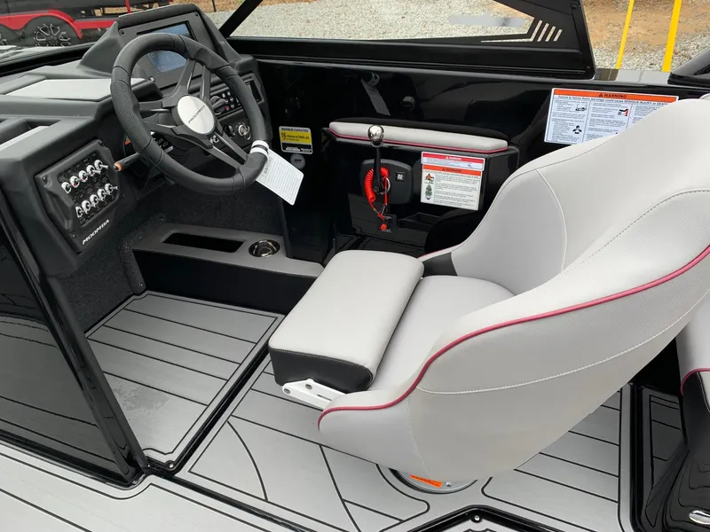 Slide: The Image of 2019 Moomba Craz boat interior with steering wheel, control panel, and cushioned seat. - 10