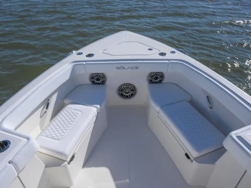 Slide: The Image of 2024 Solace 37 CS boat interior with cushioned seating and speakers on calm water. - 10