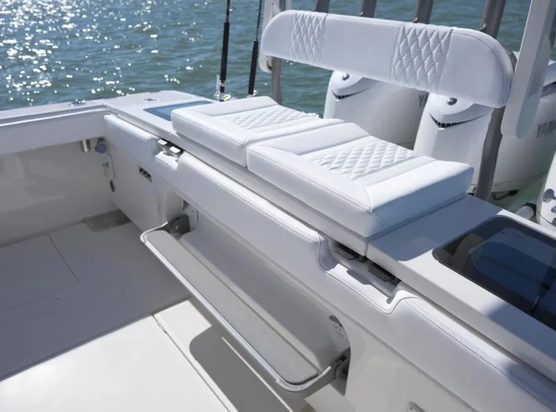 Slide: The Image of 2024 Solace 37 CS boat with white cushioned seating and footrest, on a sunny day. - 16