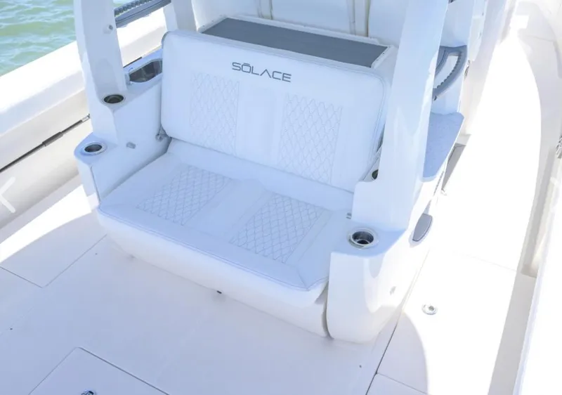 Slide: The Image of 2024 Solace 37 CS boat seating with white cushioned bench and cup holders. - 4