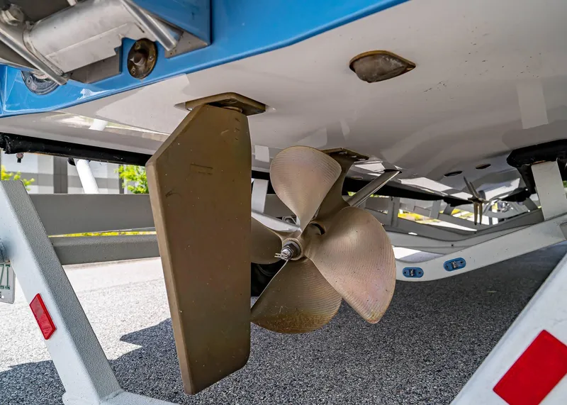 Slide: The Image of 2024 Malibu Wakesetter 24 MXZ boat propeller and rudder detail on trailer. - 13