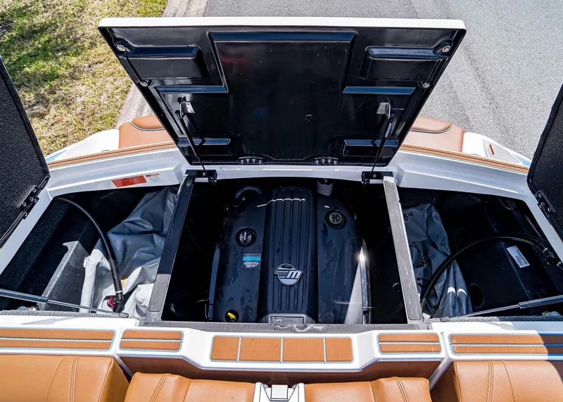 Slide: The Image of 2024 Malibu Wakesetter 24 MXZ engine compartment with open hatch, showcasing interior components. - 16