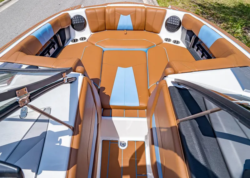 Slide: The Image of 2024 Malibu Wakesetter 24 MXZ boat interior with brown and blue seating. - 26