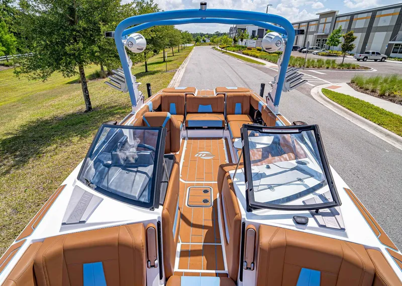 Slide: The Image of 2024 Malibu Wakesetter 24 MXZ boat with luxurious seating and modern design on a sunny day. - 28