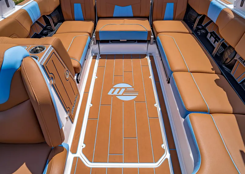 Slide: The Image of 2024 Malibu Wakesetter 24 MXZ interior with brown and blue seating, stylish flooring. - 30