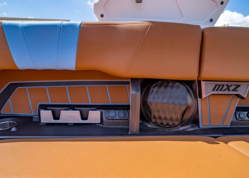 Slide: The Image of 2024 Malibu Wakesetter 24 MXZ interior with tan and blue upholstery, featuring MXZ branding. - 33
