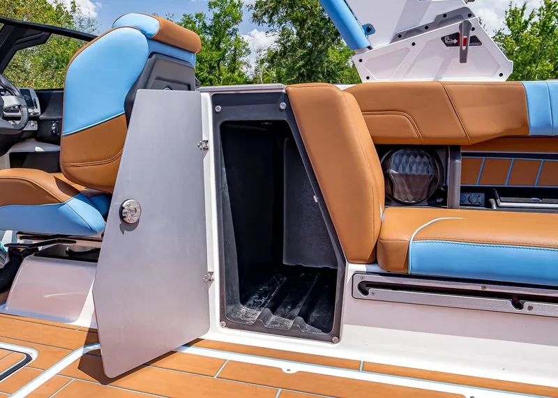 Slide: The Image of 2024 Malibu Wakesetter 24 MXZ interior with open storage compartment and stylish seating. - 35