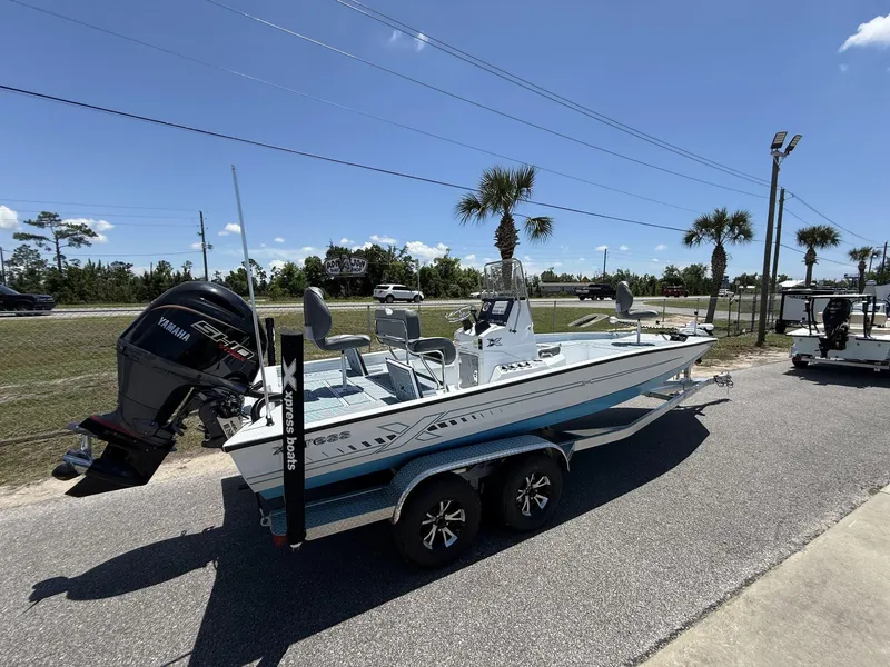Slide: The Image of 2025 Xpress Hyper-Lift Series H22B boat on trailer, parked outdoors under clear sky. - 2