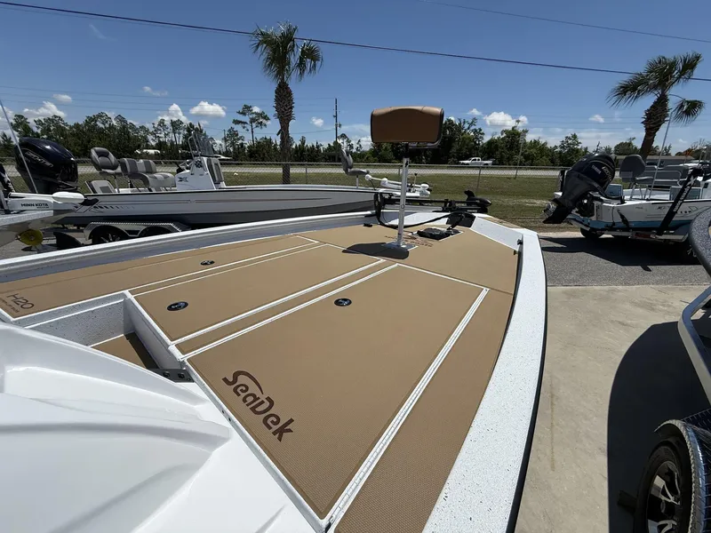 Slide: The Image of 2025 Xpress Hyper-Lift Bass Series boat with SeaDek flooring, parked outdoors under clear skies. - 4
