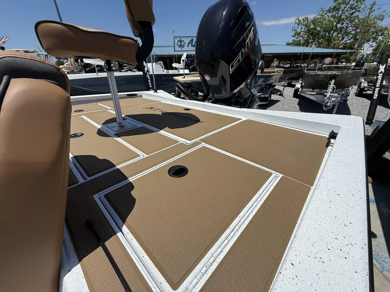 Slide: The Image of 2025 Xpress Hyper-Lift Bass Series boat deck with seating and motor, in a marina setting. - 7
