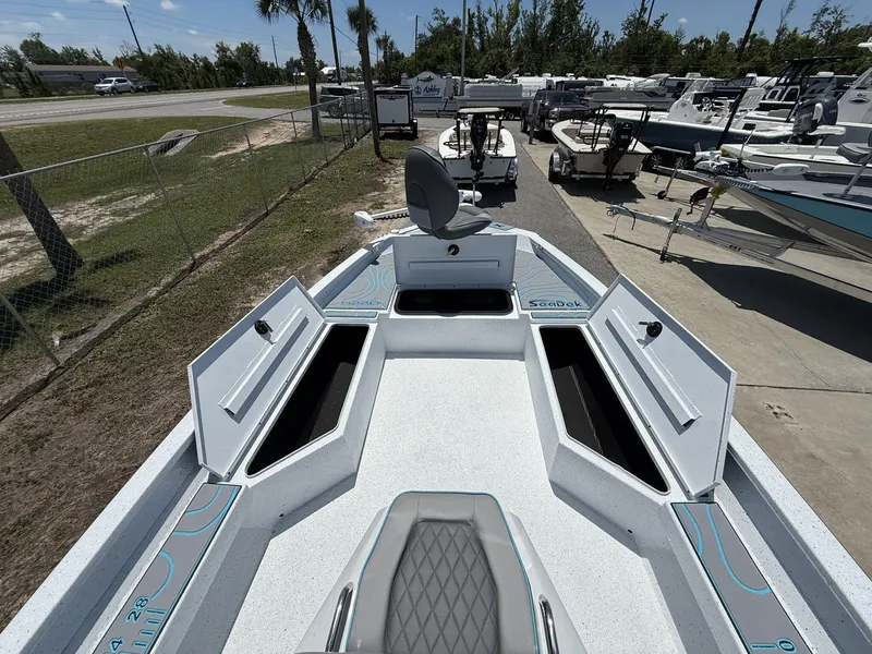 Slide: The Image of 2025 Xpress Hyper-Lift Series H22B boat with open storage compartments, parked outdoors. - 4