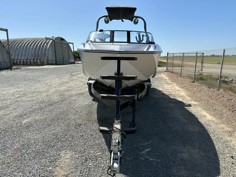Slide: The Image of 2019 Nautique Super Air Nautique G23 boat on trailer, parked on gravel road. - 3