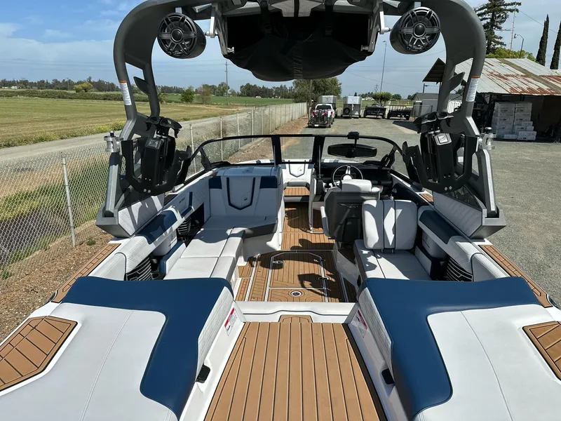 Slide: The Image of 2019 Nautique Super Air Nautique G23 boat interior with blue and white seating, outdoor setting. - 5