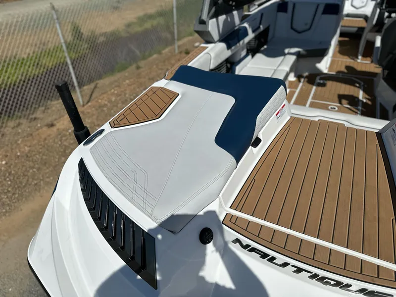 Slide: The Image of 2019 Nautique Super Air Nautique G23 boat interior with teak flooring and cushioned seating. - 6