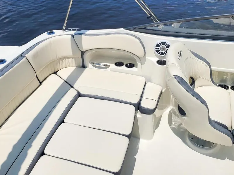 Slide: The Image of 2025 Stingray 211 DC boat interior with white cushioned seating and cup holders. - 17