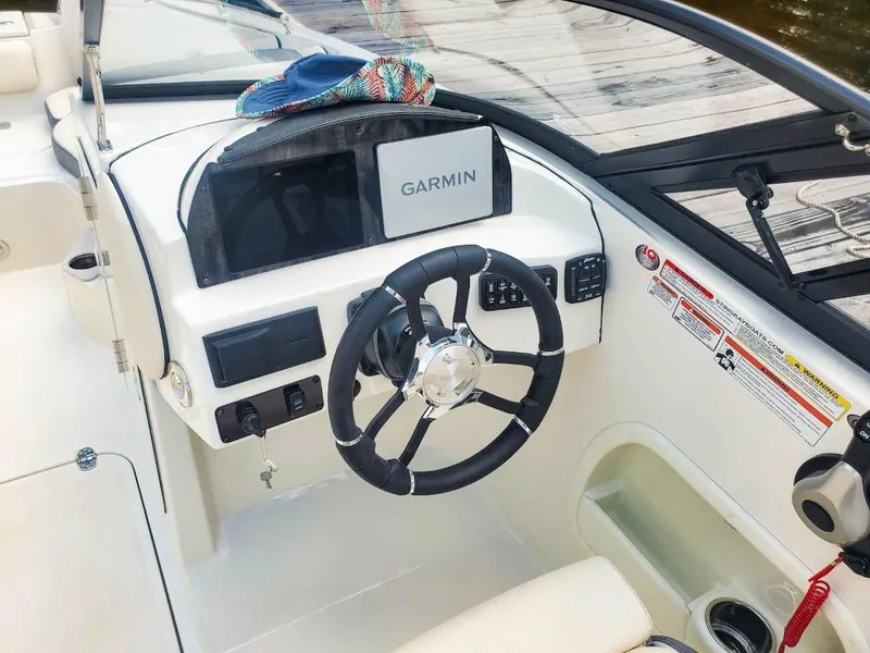 Slide: The Image of 2025 Stingray 211 DC boat dashboard with Garmin navigation system and steering wheel. - 6