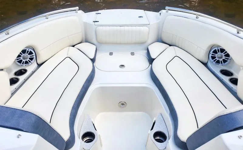 Slide: The Image of 2025 Stingray 211 DC boat interior with white cushioned seating and built-in speakers. - 7