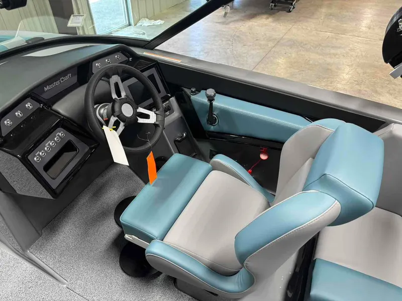 Slide: The Image of Interior of 2025 MasterCraft NXT24 boat with modern steering and blue-gray seating. - 10