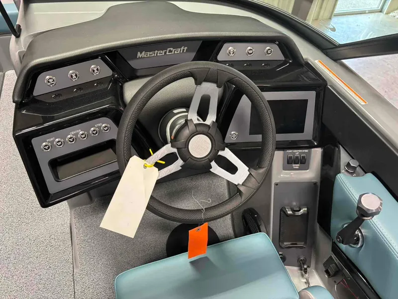 Slide: The Image of 2025 MasterCraft NXT24 boat dashboard with steering wheel and control panel. - 11