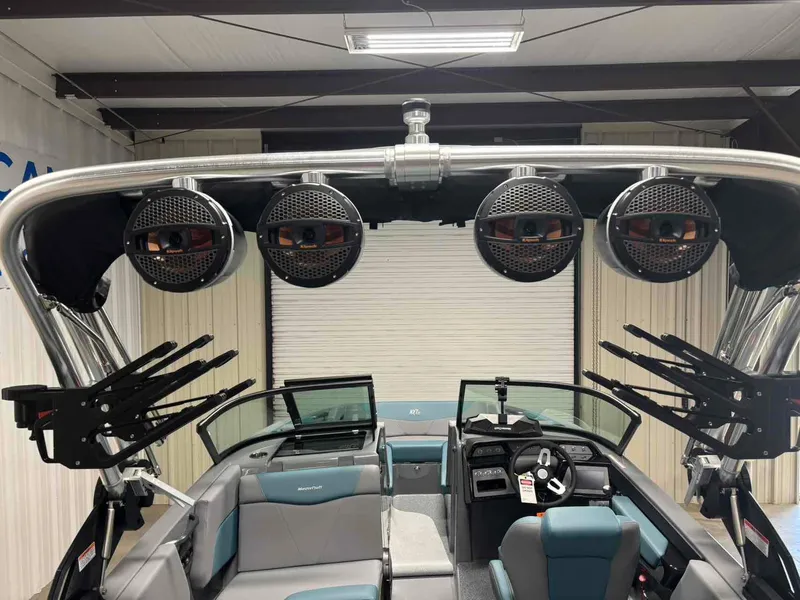 Slide: The Image of 2025 MasterCraft NXT24 boat interior with speakers and seating in a showroom. - 7