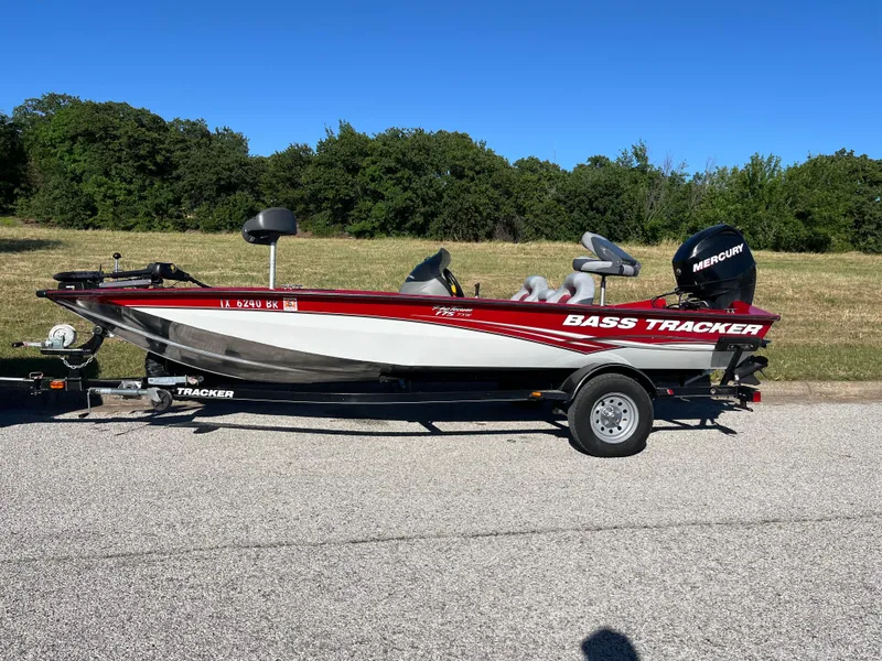 Slide: The Image of 2012 Tracker Pro Team 175 TXW bass boat on trailer, parked on a road. - 13