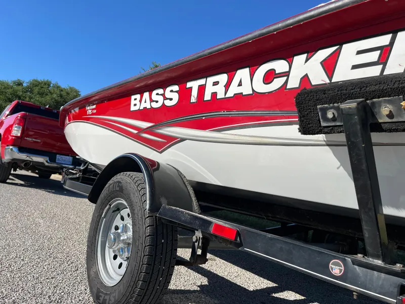 Slide: The Image of 2012 Tracker Pro Team 175 TXW boat on trailer, red and white design, parked outdoors. - 17