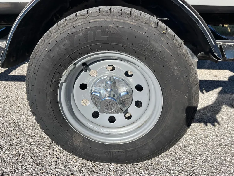 Slide: The Image of 2012 Tracker Pro Team 175 TXW trailer wheel on asphalt surface. - 18