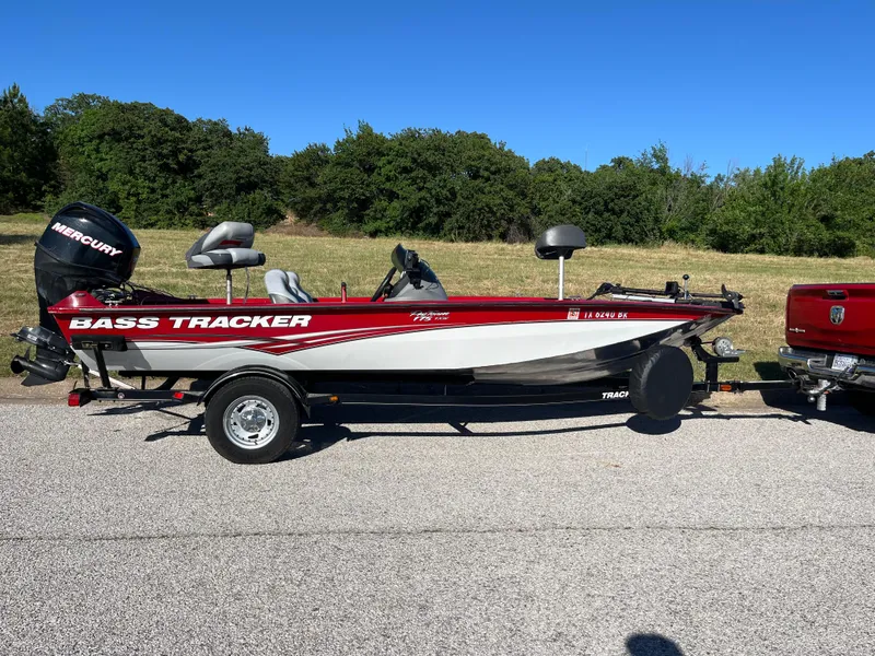 Slide: The Image of 2012 Tracker Pro Team 175 TXW bass boat on trailer, parked outdoors. - 34