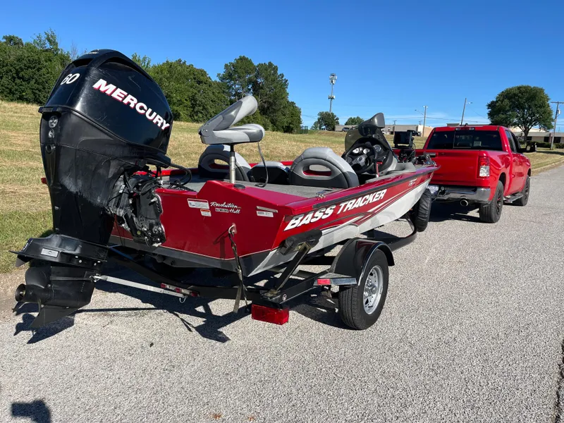 Slide: The Image of 2012 Tracker Pro Team 175 TXW boat on trailer, red with Mercury engine, parked outdoors. - 37